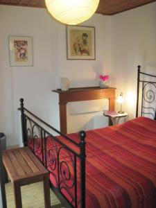 1 dormitorio con 1 cama con manta roja y silla en Le Ribet, en Lempaut