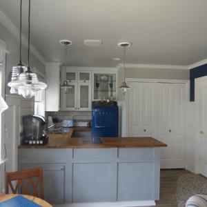 a kitchen with white cabinets and a blue refrigerator at Tanbark Shores Guest Suite in Brookings