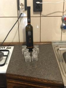 a bottle of wine and a group of cups on a counter at Luxury Eagle apartman in Budapest