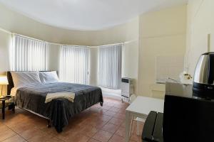 a bedroom with a bed in a room with windows at Pads on Pasadena Ave in Los Angeles