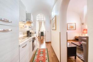 una cucina con armadi bianchi e un tavolo con un tappeto di Virgo Apartment a Roma