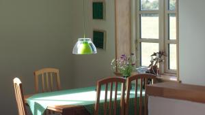 a dining room with a table and a green table and chairs at Bjældskovgaard Holiday House in Funder Kirkeby