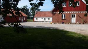 un edificio rojo y blanco con techo rojo en Bjældskovgaard Holiday House en Funder Kirkeby