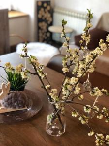 wazon wypełniony kwiatami na drewnianym stole w obiekcie Holiday house Vukelic w mieście Mrkopalj