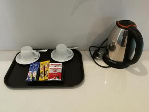 a black tray with a tea pot and a tea kettle at Double L Guest Lodge Palapye in Palatswe