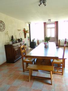 een eetkamer met een houten tafel en stoelen bij Chez Monique in Doulaincourt