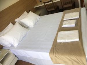 a large white bed with white pillows on it at Flat de luxo em Lagoa Santa/MG in Lagoa Santa