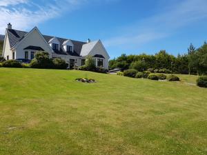 una casa en una colina con un patio verde en Creag-Ard Bed & Breakfast, en Dundonnell