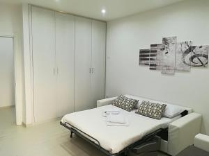 a white bedroom with a bed and a painting on the wall at La casa di Donatella in Naples