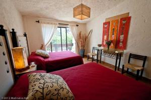 a bedroom with two beds and a table and a window at Hotel Boutique Casa de Campo Malinalco in Malinalco +28 photos