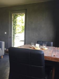 a dining room table with chairs and a table with glasses on it at Côté Campagne in Durbuy