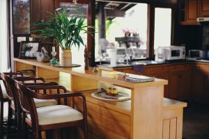 a kitchen with a counter with chairs and a table at Villa Darakorn Hill Country House in Chiang Rai +77 photos