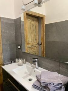 a bathroom with a white sink and a mirror at Palazzo Elisei in Gubbio +45 photos