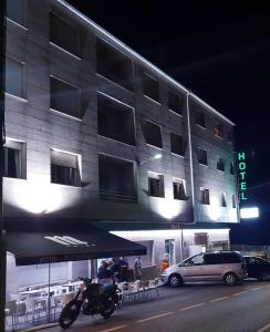 Urdilde的住宿－Hotel Camiño do Mar，夜间停在大楼前的摩托车
