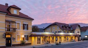 una fila di edifici su una strada al tramonto di Postwirt a Seeboden