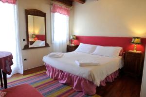 1 dormitorio con cama roja y blanca y espejo en B&B Vicenza San Rocco, en Vicenza
