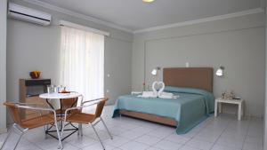 una camera da letto con un letto, un tavolo e delle sedie di Nidri Bay Studios a Nydri Altre 24 foto