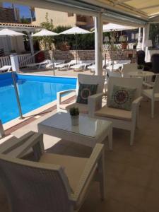 un patio con tavolo e sedie accanto alla piscina di Nidri Bay Studios a Nydri
