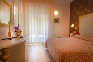 Habitación de hotel con cama y ventana en Hotel Acquamarina, en Bellaria-Igea Marina