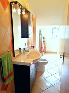 a bathroom with a sink and a toilet and a mirror at Casa do Vale in São Vicente