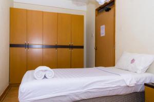 a bedroom with a bed with two towels on it at Aponye Hotel Kampala in Kampala