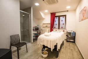 um quarto com uma cama, uma cadeira e um chuveiro em Hotel Lido degli Spagnoli Wellness & Spa em Portoscuso