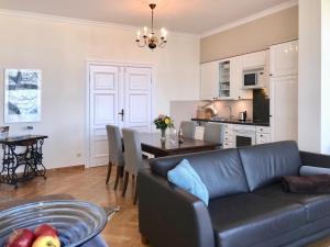 ein Wohnzimmer und eine Küche mit einer Couch und einem Tisch in der Unterkunft Meerblick - Villa Achterkerke in Heringsdorf