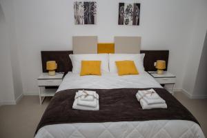 a bedroom with a large white bed with towels on it at LA CIVITA B&B in Gravina in Puglia