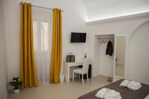 1 dormitorio con escritorio, 1 cama y 1 mesa en LA CIVITA B&B, en Gravina in Puglia
