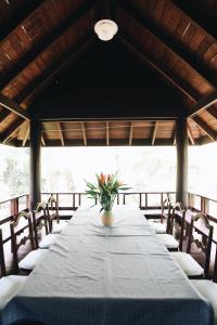 a long table with chairs and a vase of flowers on it at Villa Darakorn Hill Country House in Chiang Rai