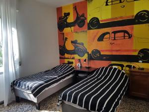 2 letti in una camera con un dipinto sul muro di ComoVà a Maslianico