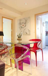comedor con mesa de cristal y sillas rojas en Le Gite d'Emilie, en Entraygues-sur-Truyère