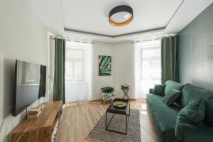 ein Wohnzimmer mit einem grünen Sofa und einem Tisch in der Unterkunft Royal Vega Apartment in Ljubljana