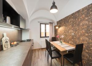 eine Küche mit einem Holztisch mit Stühlen und einer Theke in der Unterkunft Royal Vega Apartment in Ljubljana