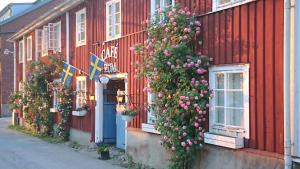 Un bâtiment rouge avec des fleurs sur son côté dans l'établissement Garvaregården Hotel , B&B och Café, à Askersund