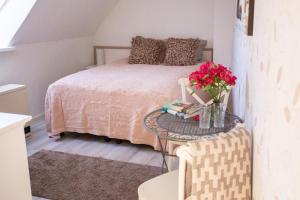 Un dormitorio con una cama y una mesa con flores. en Suviste Guesthouse en Kuressaare