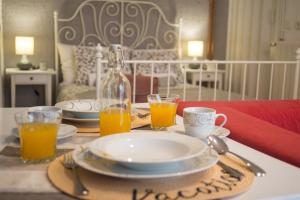 a table with a plate and two glasses of orange juice at Apartment Lara in Kraljevica