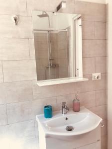 a bathroom with a white sink and a mirror at Case vacanze I trabocchi in San Vito Chietino