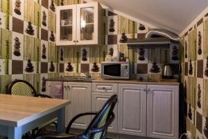 a kitchen with a microwave and a table with chairs at Tindioru in Rõuge