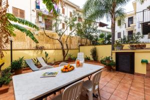 patio con tavolo, sedie e arance di Solemar Sicilia - Casa Maria a Santa Flavia