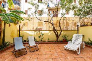 a patio with three chairs and a tree at Solemar Sicilia - Casa Maria in Santa Flavia