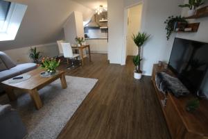 a living room with a couch and a tv and a table at Ferienwohnung Am See in Rhauderfehn