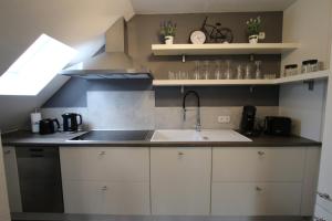 a kitchen with a sink and a counter top at Ferienwohnung Am See in Rhauderfehn +34 photos
