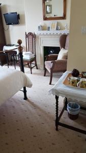 a living room with a table and a fireplace at Kenella House in Minehead