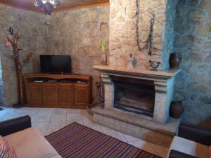 a living room with a fireplace and a television at Casa Retiro de Xisto in Videmonte