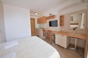 a bedroom with a bed and a kitchen with a desk at Apartmani Ljubo Rafailovic 2 in Rafailovici