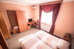 Schlafzimmer mit einem Bett, einem Fenster und einem Schreibtisch in der Unterkunft Hotel Drumski Raj in Svilajnac