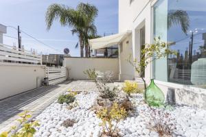 a garden with white rocks and a green vase at Viva Vacanze in Porto Cesareo +25 photos