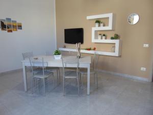 a dining room with a white table and chairs at Case Vacanza Donatella in San Vito lo Capo