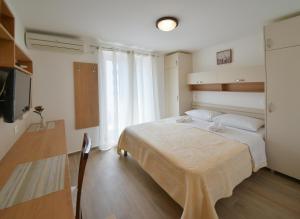 a hotel room with a bed and a television at Apartmani Ljubo Rafailovic 2 in Rafailovici